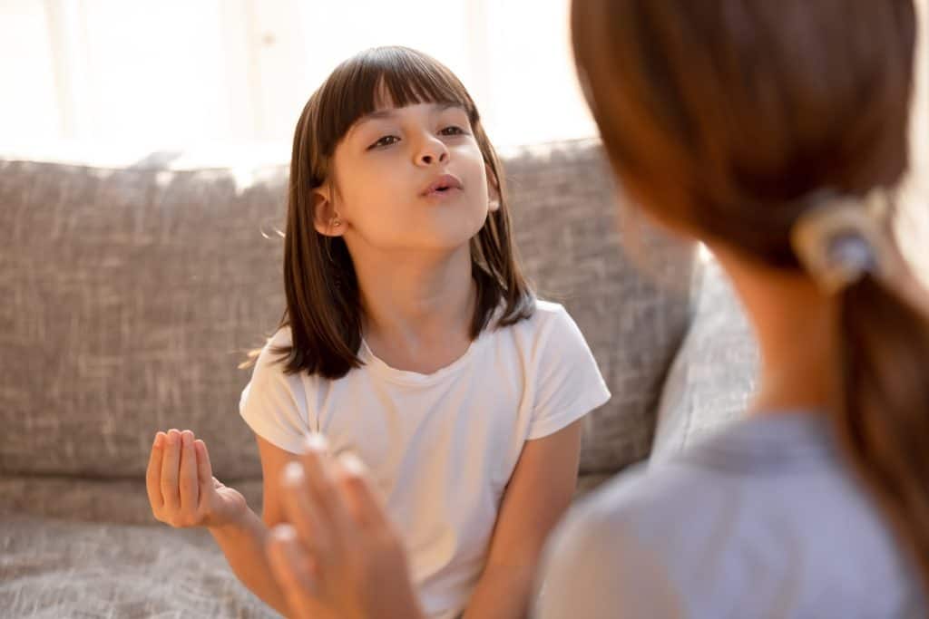 Stuttering child speaking doing exercises with speech therapist