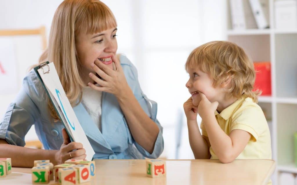 Speech therapist helping boy with stutter
