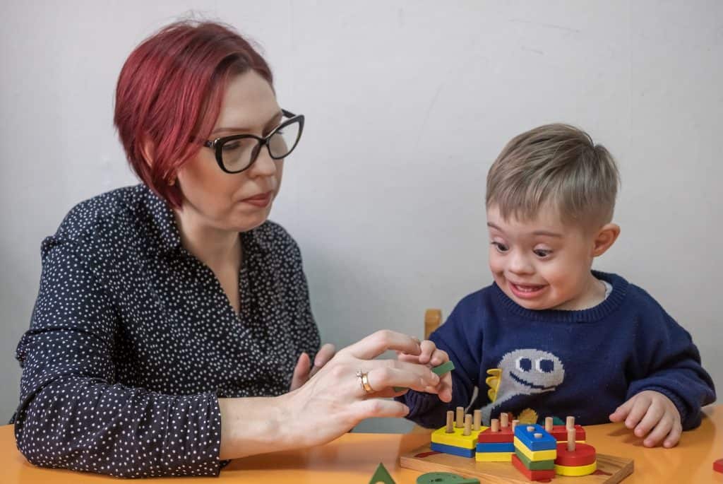 Child living with down syndrome playin speech game with Speech Therapist